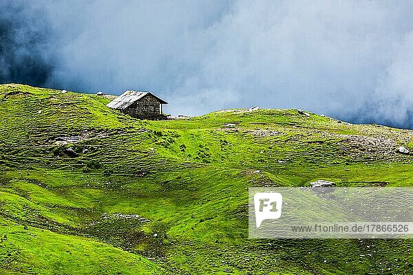 Gelassenheit heitere einsame Landschaft Hintergrund Konzept  Haus in den Hügeln in mountins auf alpine Wiese in Wolken