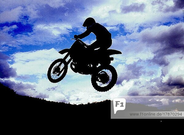 Motocross rider jumping  backlight