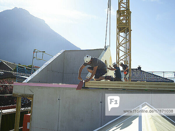 Tischler installieren an einem sonnigen Tag das Dach auf der Baustelle