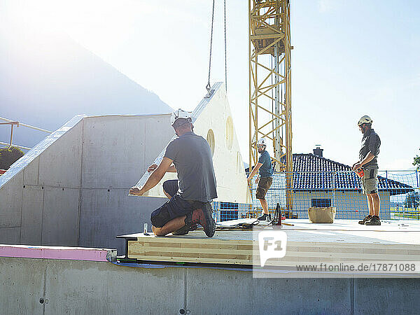 Construction workers installing roof on sunny day