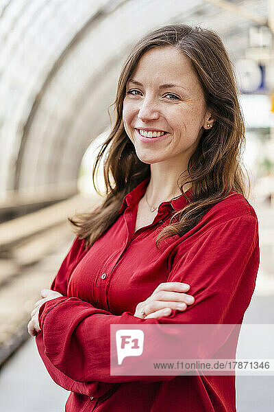 Smiling woman standing with arms crossed