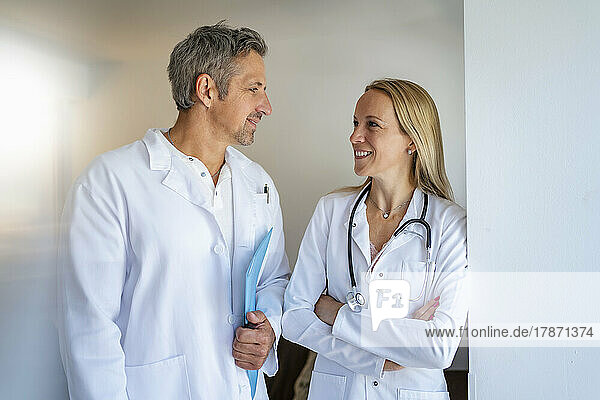 Männlicher und weiblicher Arzt schauen einander an