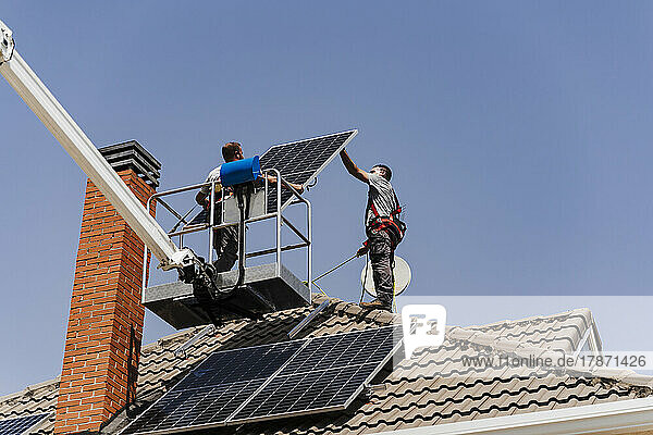 Technicians unloading solar panel from hydraulic platform
