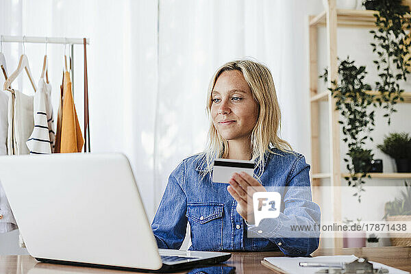 Businesswoman doing online shopping through credit card at home office
