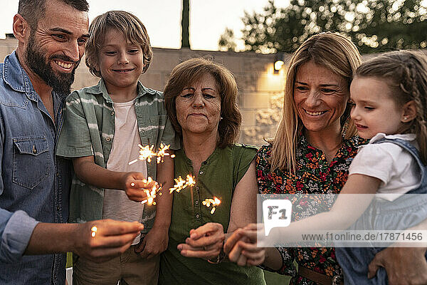 Smiling family burning sparklers together
