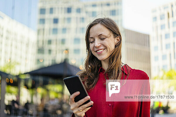 Smiling woman using mobile phone