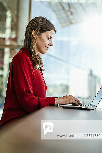Businesswoman working on laptop at work place
