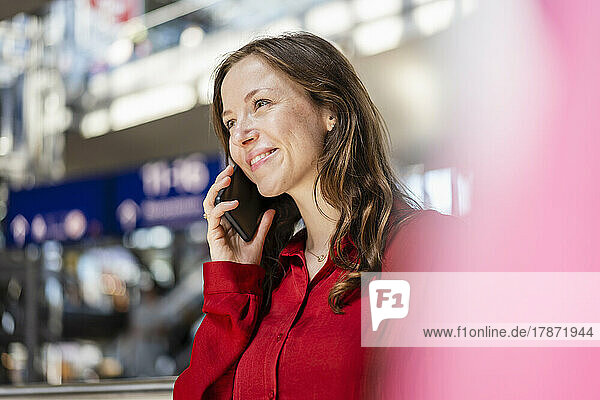 Smiling woman with brown hair talking on mobile phone