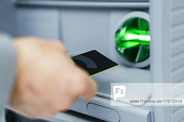 Businessman using credit card at ATM machine