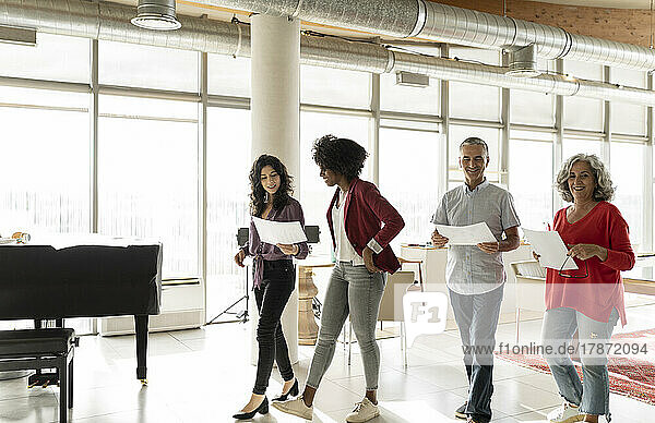 Businessman and businesswomen with documents walking in office