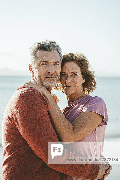 Loving mature couple at beach on sunny day