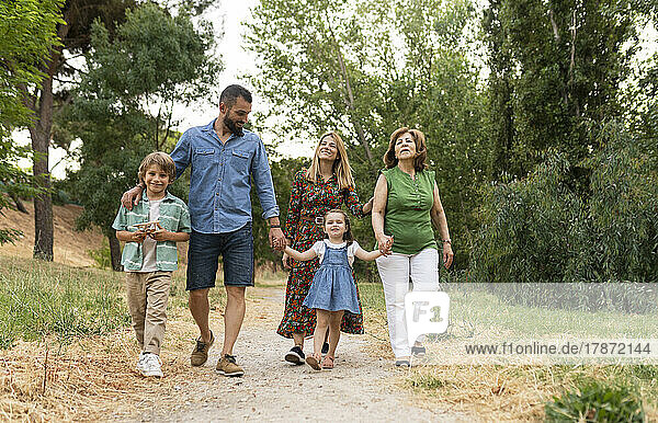 Smiling family walking on dirt road