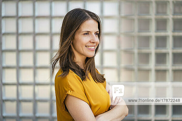 Smiling businesswoman with arms crossed in office