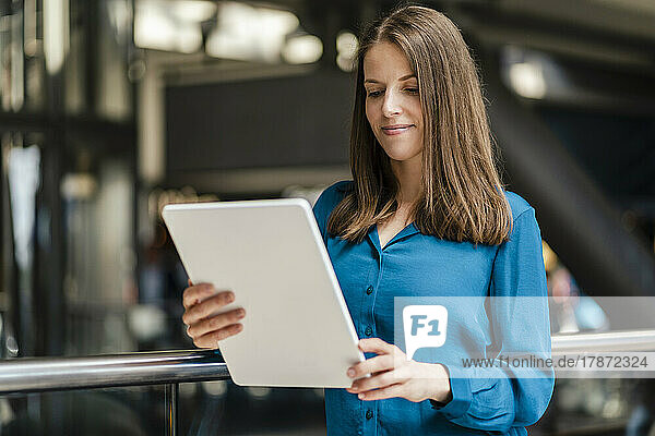 Businesswoman using tablet PC by railing