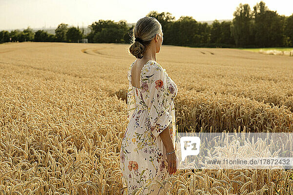 Senior woman standing in wheat field