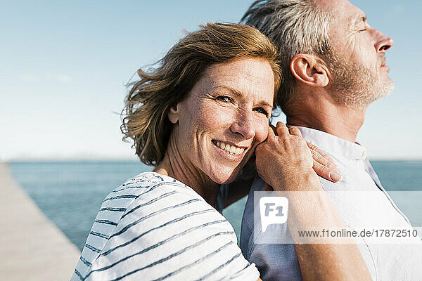 Happy mature woman standing with man on sunny day