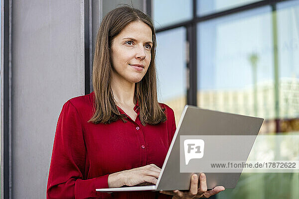 Thoughtful businesswoman working on laptop
