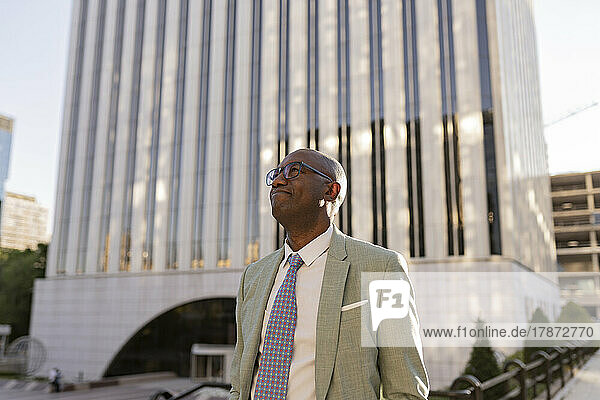 Mature businessman wearing eyeglasses standing in financial district