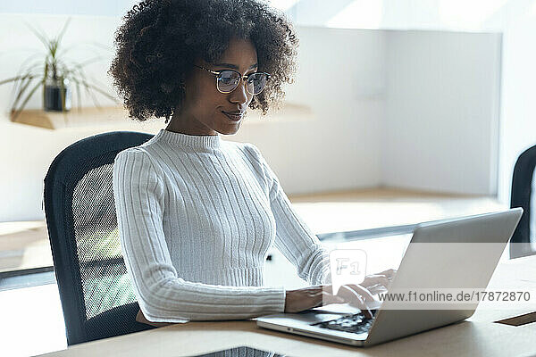 Junge Geschäftsfrau arbeitet im Büro am Laptop
