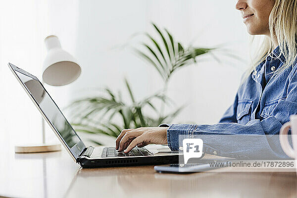 Businesswoman typing on laptop at home office