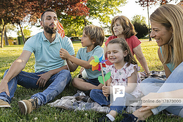 Happy family playing with pinwheels at park