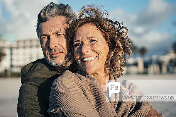 Lächelnde blonde Frau und Mann genießen den Urlaub am Strand