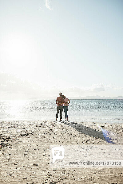 Älteres Paar steht an einem sonnigen Tag am Strand