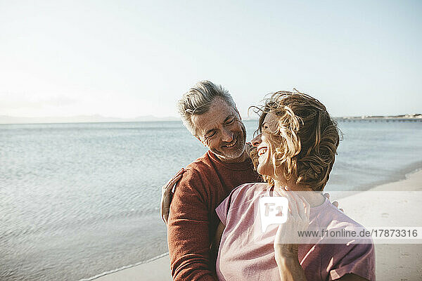 Glückliche blonde Frau und Mann genießen den Urlaub am Strand