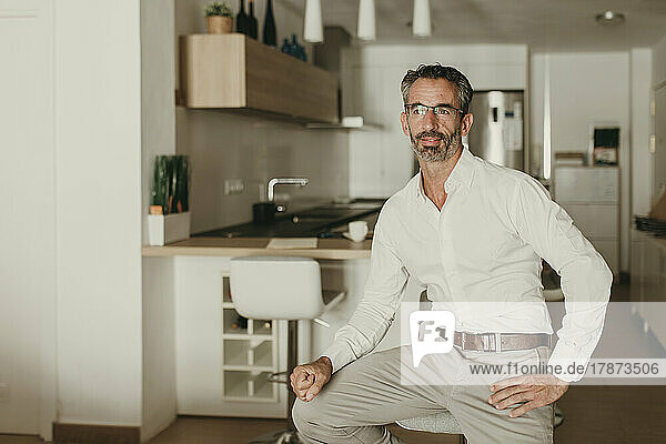 Thoughtful mature businessman in kitchen at home