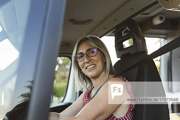 Smiling mature woman sitting in motor home
