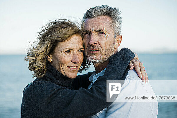 Mature couple in front of sea on sunny day