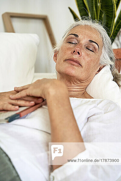 Mature woman sleeping on couch at home