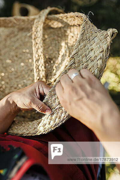 Hands of craftswoman weaving esparto grass basket
