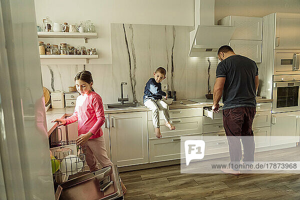 Father with children in kitchen at home