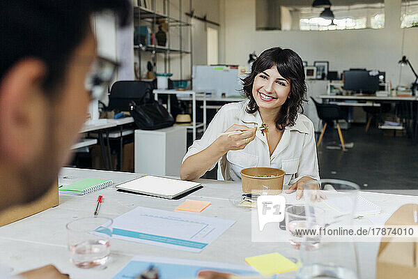 Smiling businesswoman having with colleague in break at office