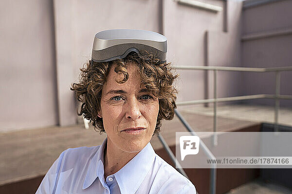 Real estate agent with brown curly hair wearing virtual reality simulator