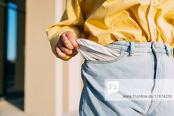 Woman showing empty pocket of jeans