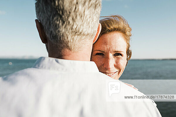 Smiling woman standing in front of man on sunny day