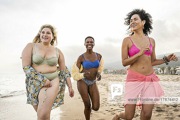Sorglose gemischtrassige Frauen  die Spaß am Strand haben