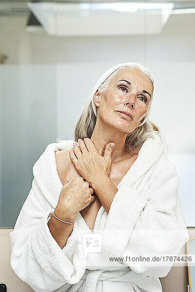 Frau massiert Nacken im Badezimmer zu Hause