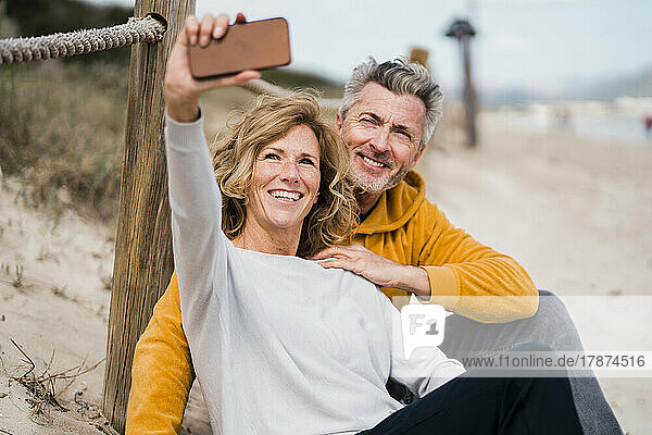 Glücklicher reifer Mann und Frau  die am Strand ein Selfie mit dem Handy machen