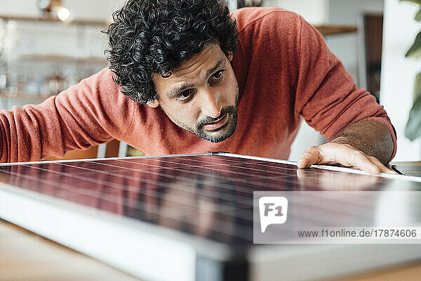 Businessman examining solar panel in office
