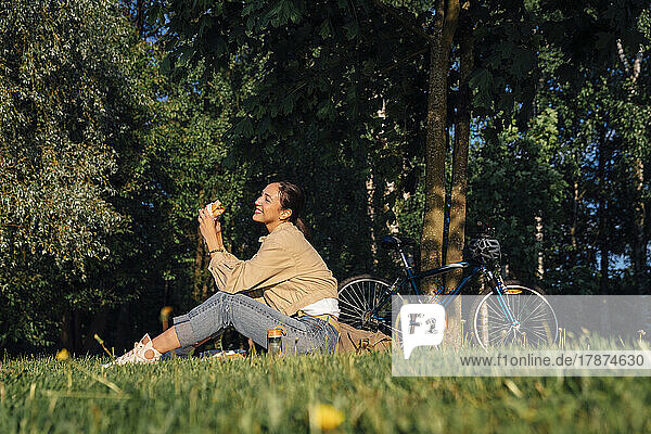 Happy woman having lunch in park on sunny day