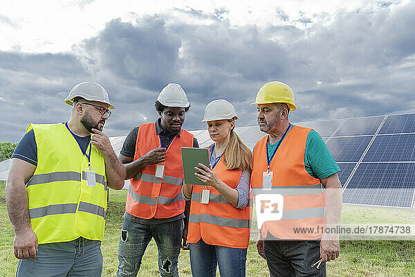 Engineers discussing over tablet PC at solar station