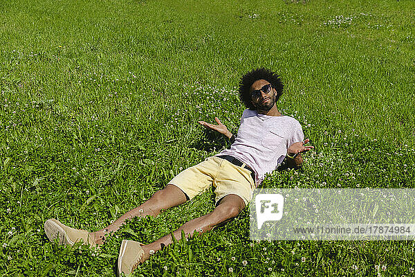 Man lying on grass gesturing in park