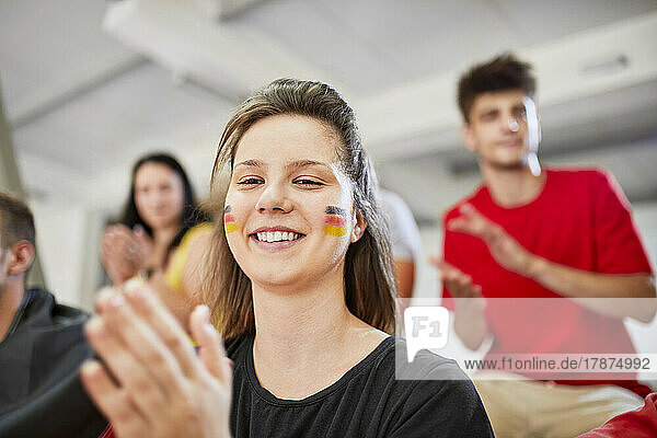 Smiling woman applauding at sports event in stadium