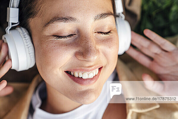Smiling woman with headphones listening music