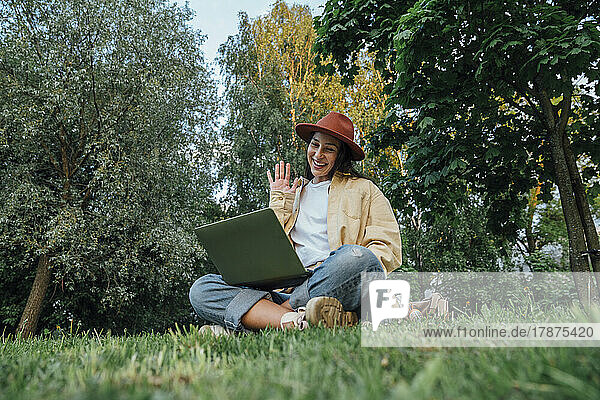 Smiling woman talking on video call over laptop at park