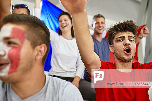 Man shouting with sports fans in stadium