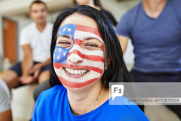 Cheerful woman with American Flag painted on face
